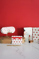 Red Hearts collection – glasses case and card holder with red hearts pattern on white background, displayed on wooden stand against red wall.