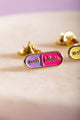 Duo Anti Idiots - Pins: close-up of the pink and purple "anti idiots" enamel pin with gold lettering.