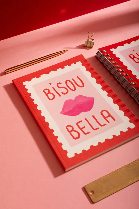 Bisou Bella - Notebook A5: a vibrant red and pink notebook with a lips illustration, styled with a gold pen and ruler.