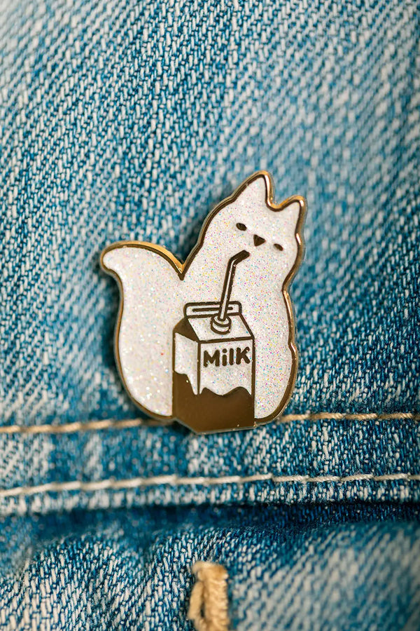 Detailed view of the Cat Milk Enamel Pin with glitter finish