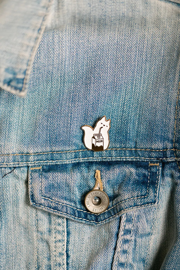 Cat Milk Enamel Pin on a denim jacket pocket