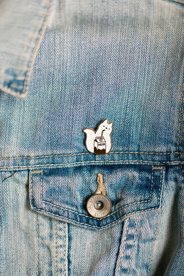 Cat Milk Enamel Pin on a denim jacket pocket