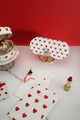Lifestyle shot of red hearts glasses case with matching accessories, notebooks and lipstick on marble surface