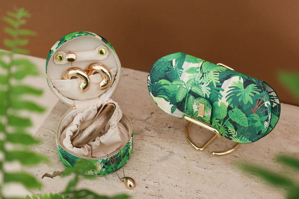 Close-up of Green Cliff jewelry case and glasses case with green tropical leaf design.
