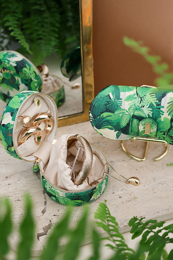 Tropical Green Cliff round jewelry case and glasses case with botanical print, styled with golden jewelry.
