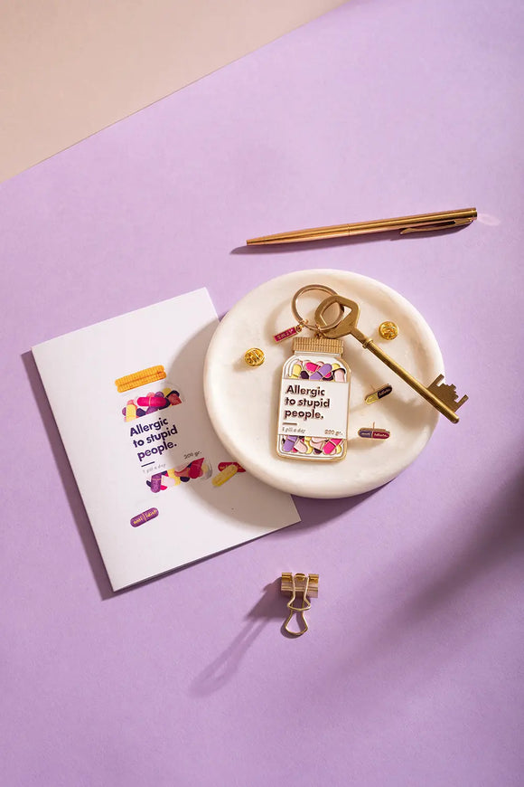 Allergic to stupid people Greeting card - Close up of the card and gold stationery accessories.