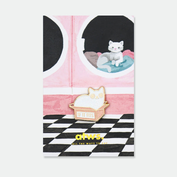 Enamel pin of a white cat squeezed into a pink box labeled "If it fits"