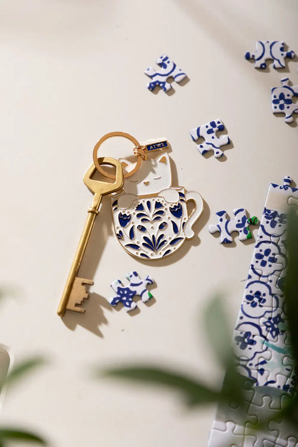 Cat in a mug Keychain - Top view of the white cat illustration in a floral blue mug.