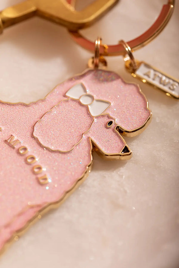 Poodle mood Keychain - Close-up on the poodle's head featuring a white bow and golden ATWS logo tag.