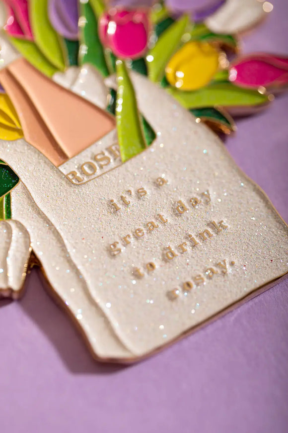 Rosay day Keychain - Detailed focus on the glittery enamel and "it's a great day to drink rosay" golden engraving.