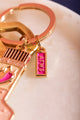Spicy & Hot Keychain - Detail of the pink and gold ATWS logo charm on the key ring.