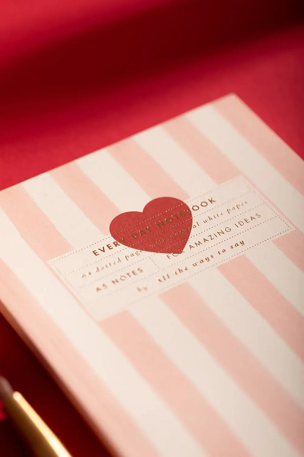 Pink stripes Notebook A5 - Angled view of the pink and white striped cover with a red heart.