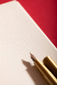 Pink stripes Notebook A5 - Close-up of the interior dotted pages and golden pen detail.