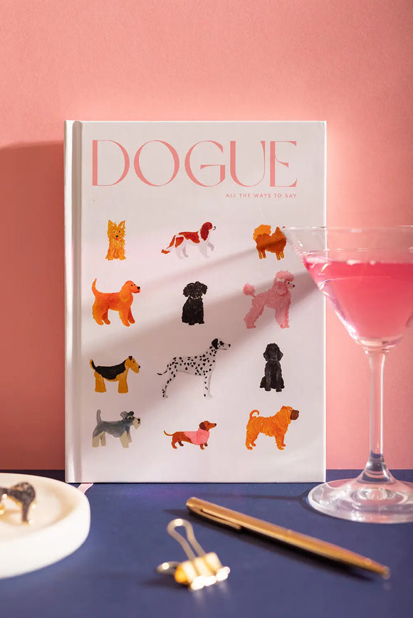 Dogue Hardcover Notebook A5 - Front view on a navy background with a pink cocktail and gold pen.