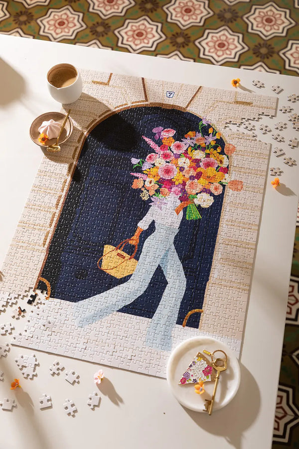 Parisian Door - Puzzle 1000 pieces: wide view of the puzzle styled with lifestyle accessories and a golden key.