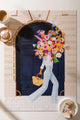 Parisian Door - Puzzle 1000 pieces: a complete view of the assembled puzzle featuring a woman with a large floral bouquet at a navy door.