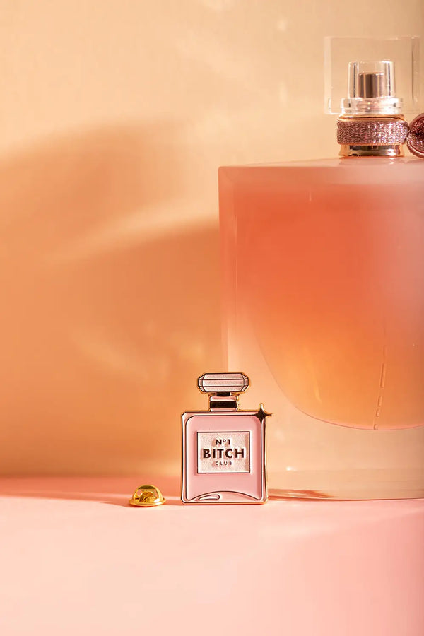 N°1 Bitch - Pins: front view of the "N°1 Bitch Club" pink enamel pin with gold lettering and star detail.