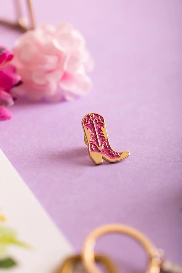 Pink Santiag - Pins: glittery pink cowboy boot enamel pin with gold detailing on a soft purple background.
