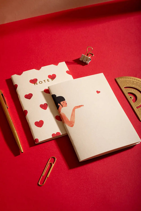 Bisou Pocket Notebook A6 DUO - Lifestyle view on a red desk with gold stationery.