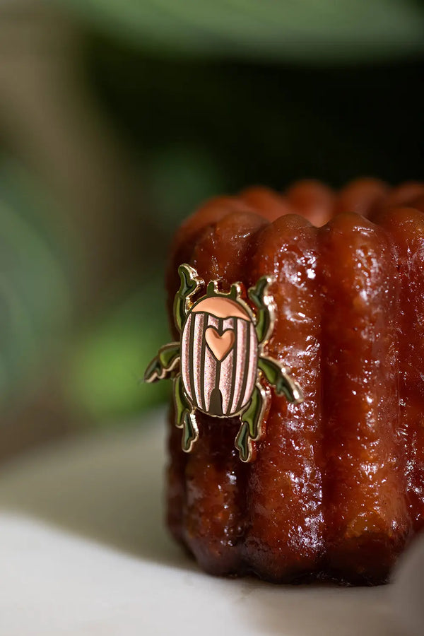 Duo Scarabée - Pins: macro shot of the pink and green glittery enamel beetle pin showing intricate gold plating.