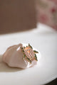 Duo Scarabée - Pins: the pink heart scarab pin placed on a white meringue for a creative product display.