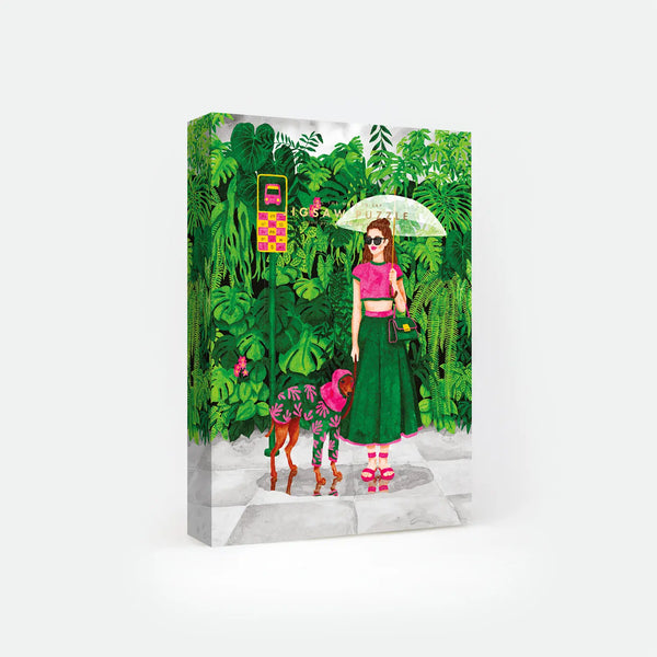 Wet Season 1000-piece jigsaw puzzle box by All The Ways To Say, illustration of a woman with an umbrella and her dog in a raincoat standing at a jungle bus stop, text reads "Jigsaw Puzzle".