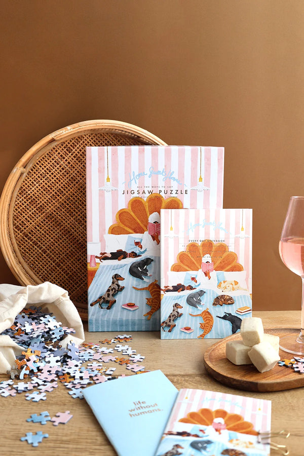 Home Sweet Home jigsaw puzzle and notebook with animal illustration styled with puzzle pieces and cozy tabletop decor